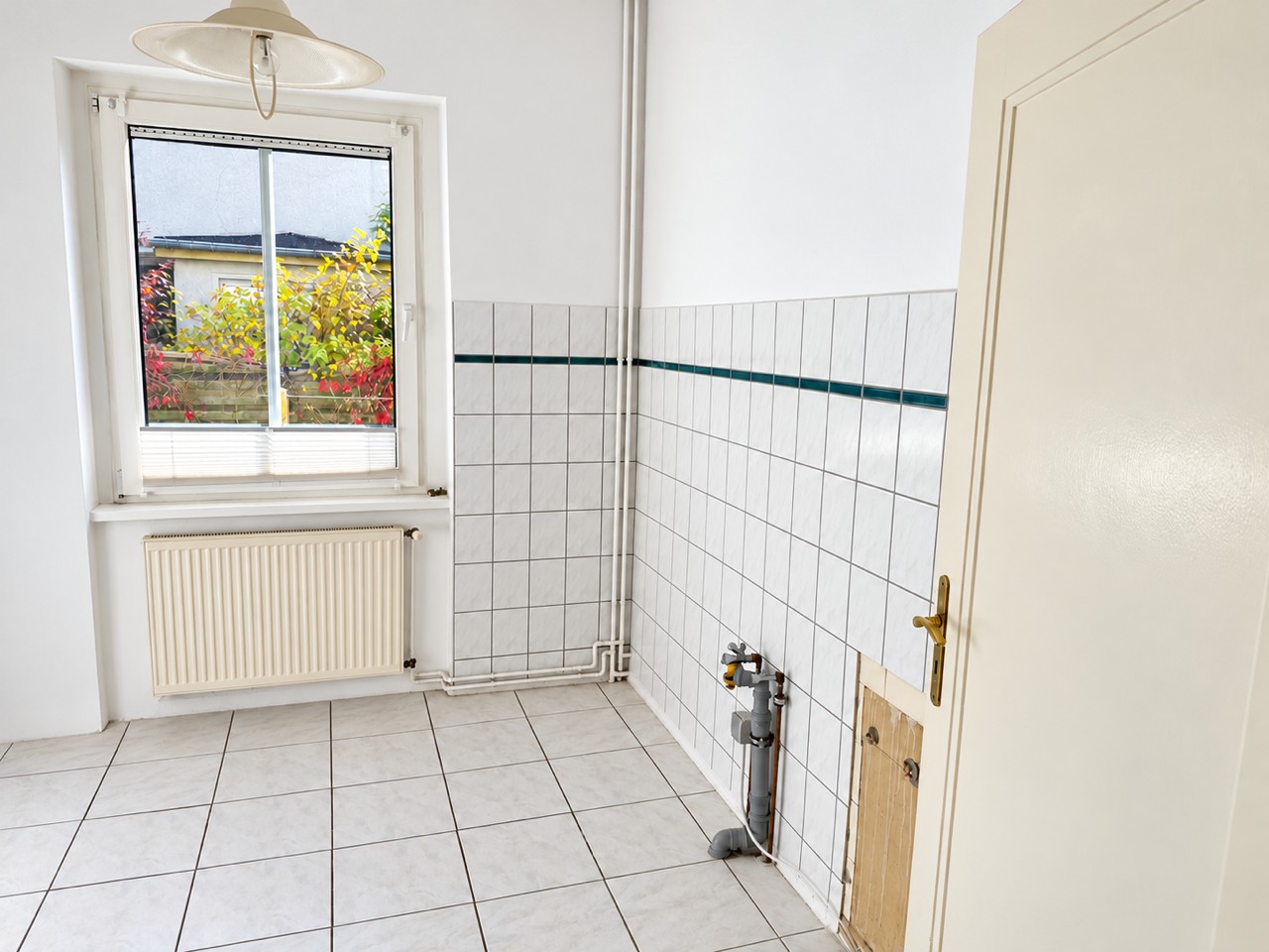 Küchenraum mit Fenster und sichtbaren Küchenanschlüssen