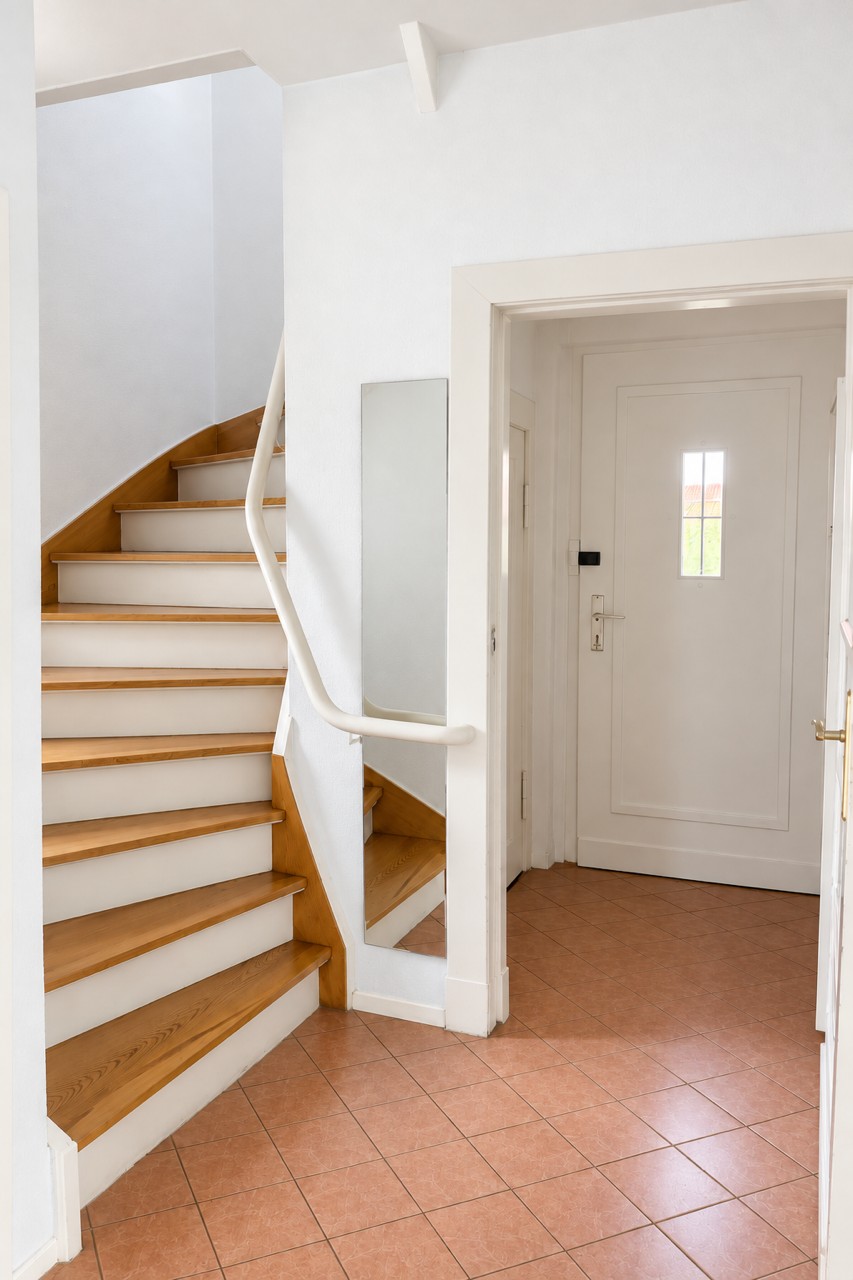 Holztreppe und Eingangstür im Einfamilienhaus