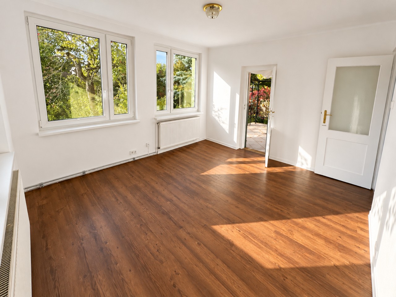 Heller Wohnraum mit Holzboden und Zugang zum Garten