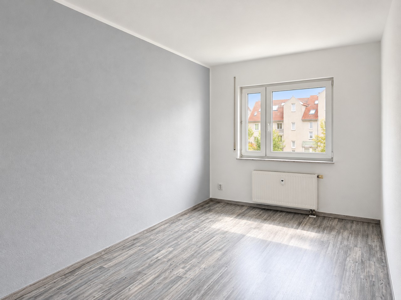 Helles weiteres Zimmer mit Fenster ins Grüne